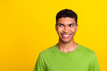 Photo of positive minded person beaming smile look interested empty space isolated on yellow color background