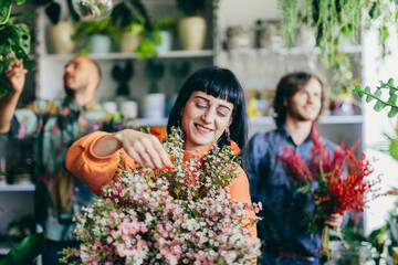 Woman working with florists in flower store