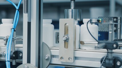 Automated production line conveyor in a factory with screw caps on glass bottles. Medical Conveyor Production of Pharmaceuticals. Twist Bottles. Pharmaceutical Industry. Close up, DOF