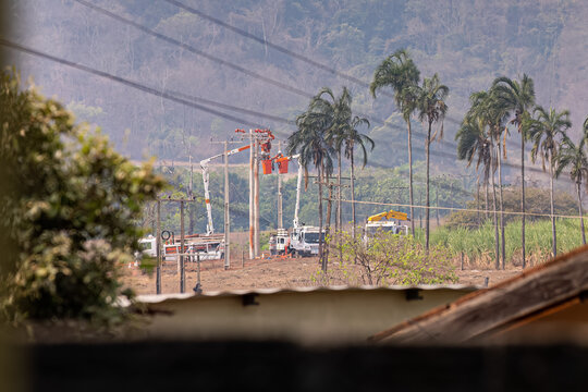 electric company employees carrying out repairs on poles