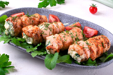 Chicken rolls stuffed with lettuce, egg, cheese, cucumber and sour cream served on the gray plate. Hot appetizing meal