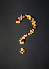Question mark sign made with assorted drug capsules and tablets. Conceptual photo for 'ask the doctor' or 'say no to self medication'.