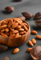 Bowl of healthy and nutritious almond seeds. Beautiful photo of a wooden bowl full of almond nuts placed with seeds with shell.