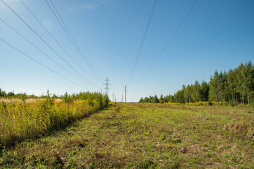 Power line towers. Out-of-town power supply system. Energy infrastructure in the fields in the countryside.