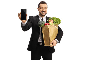 Businessman holding a bag of groceries and showing a smartphone