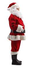 Full length profile shot of santa claus standing and holding his belly