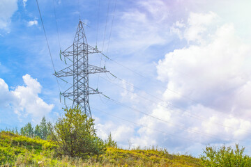 Obraz premium Countryside electric power transmission line on the background of the forest. Three-phase power transmission and supply system in remote areas.