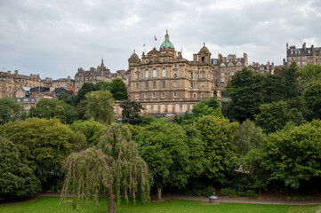 Obraz premium View from Princes street to old town and castle in Edinburgh city, view on houses, hills and trees in old part of the city, Scotland, UK