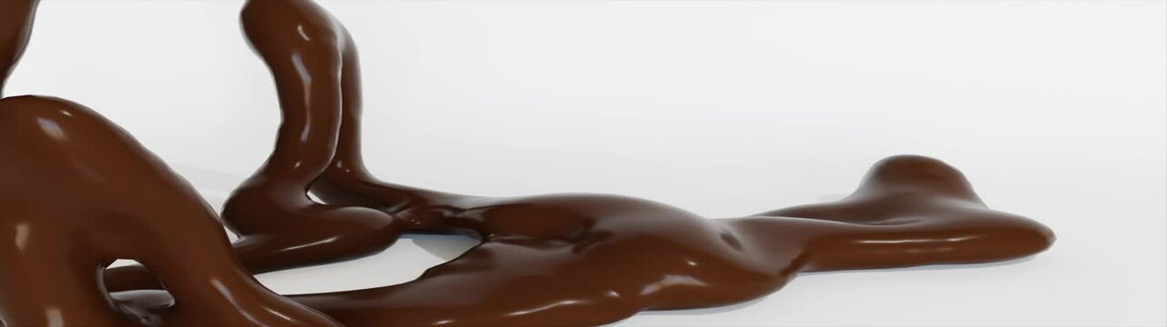 Liquid chocolate flows slowly onto a white surface