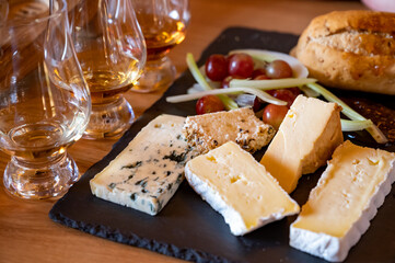 Pairing of scotch whisky and farmers scottish cheeses cheddar, stilton, blue cheese, brie, tasting of whiskey and cheese in Edinburgh, UK