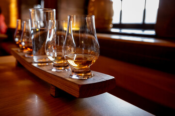 Flight of single malt scotch whisky in glasses served in whiskey bar in Edinburgh, UK