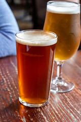 Pint glasses of british ale and lager beer served in old vintage English pub