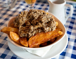 Scottish traditional snack food, hand cut potato chips topped with haggis and gravy
