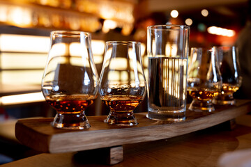 Flight of single malt scotch whisky in glasses served in whiskey bar in Edinburgh, UK