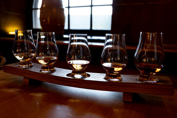 Flight of single malt scotch whisky in glasses served in whiskey bar in Edinburgh, UK