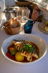 Provence cuisine, filet of seabass white fish served with potatoes, tomatoes and .Bouillabaisse jus in French restaurant