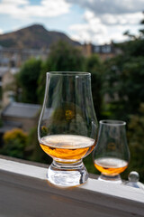 Glass of single malt scotch whisky served on old window sill in Scottisch house with view on old part of Edinburgh, Scotland, UK