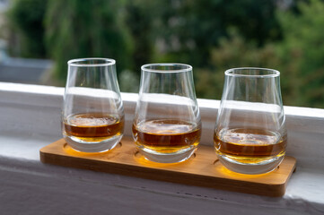 Flight of single malt scotch whisky served on old window sill in Scottisch house with view on old part of Edinburgh, Scotland, UK