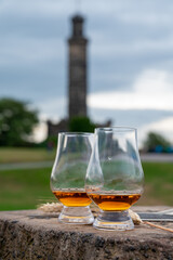 Tasting of single malt scotch whisky in glasses with view from Calton hill to new and old parts of Edinburgh city in rainy day, Scotland, UK