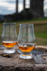 Tasting of single malt scotch whisky in glasses with view from Calton hill to new and old parts of Edinburgh city in rainy day, Scotland, UK