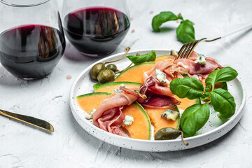 Fresh melon with prosciutto and basil. Antipasti, Traditional Spanish and Italian appetizer. Top...