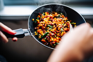 cooking tasty vegetable mix with corn, pea, beans in pan on kitchen