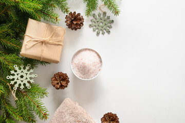 Winter body care and Christmas Spa concept with gift, cosmetic sea salt on white background. View from above. Special offer for beauty services. Copy space.