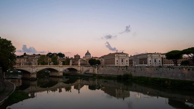 Time lapse video from night to day of Rome Skyline with the famous Vatican St Peter Basilica and St Angelo Bridge above Tiber River in Rome, Italy. Sunrise view with moving clouds.