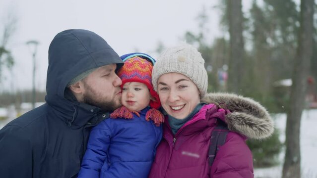 happy family spend time outdoors snowy winter view mother holding smiling daughter father kissing kid