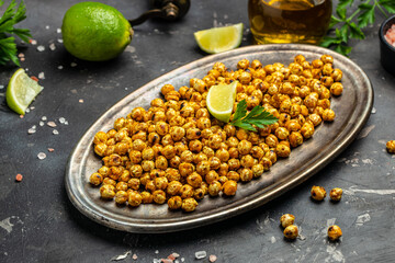 Fried roasted spicy chickpeas or Indian chana or chole with lime. Tasty vegetarian and vegan chickpea snack. Food recipe background. Close up