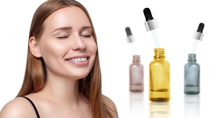 Cosmetics oil in bottles near beautiful face of young woman.