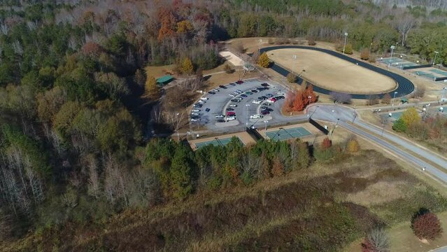 Aerial Drone View Flying Toward A Walking Track Over Tennis Court