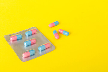 Medicine pills on a light background. Medicines and prescription pills flat lay background. Blue and pink medical tablets in blister
