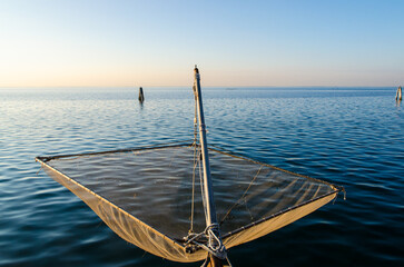 Una rete da pesca a bilancia sulla riva di Pellestrina, isola della laguna di Venezia, di fronte...