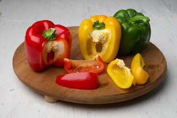 set of fresh whole and sliced red and yellow sweet bell pepper on wooden board.top view.