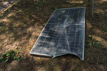 A broken solar panel, a torn panel mount lie on the ground. Consequences of a natural disaster....