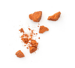 Flying pieces and powder of broken red brick isolated on white