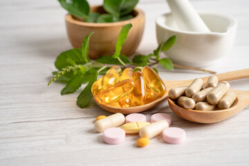 Fototapeta na wymiar Alternative medicine herbal organic capsule drug with herbs leaf natural supplements for healthy good life.