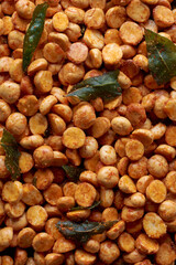 close-up macro view of roasted or fried bengal gram mixed with ground chili peppers, also known as chenna dal or pori or pottu kadalai, indian crispy and spicy snack in full frame, food background