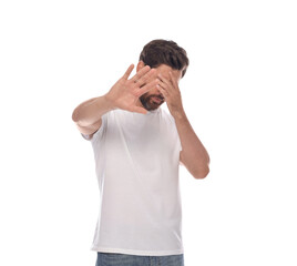 Embarrassed man covering face with hands on white background - obrazy, fototapety, plakaty
