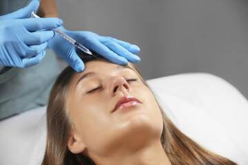 Fototapeta premium Beautiful woman getting facial injection in salon
