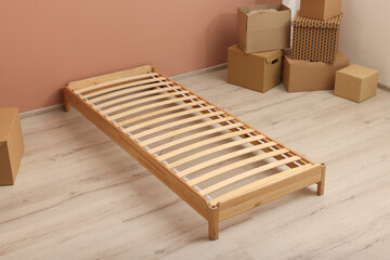 Wooden bed frame and cardboard boxes on floor in room