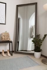 Modern hallway interior with large mirror and houseplant