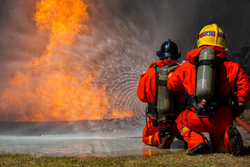 Firefighter on duty firefighting, Asian fireman spraying high pressure water, Fireman in fire...