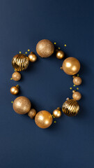 Circle frame of golden Christmas balls and glitter confetti hearts on blue background with copy space