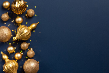 Christmas frame with golden glitter balls and toys on blue background with copy space