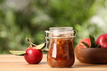 Delicious apple jam and fresh fruits on wooden table