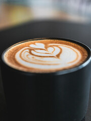 Espresso coffe cup picture in a black table background with heart art mixed with milk. Barista coffe art with latte milk on top. Delicious espresso coffe wallpaper. Peaceful environment coffeshop.