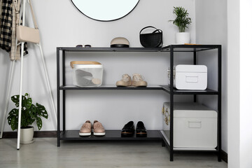 Black table with stylish shoes and accessories in hallway