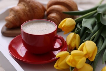 Morning coffee, flowers and croissants on white wooden tray, closeup